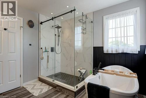 Glass-enclosed shower with subway tile surround, hexagon tile flooring, and a matte black rainfall showerhead - 61 Ditner Avenue, Baden, ON - Indoor Photo Showing Bathroom