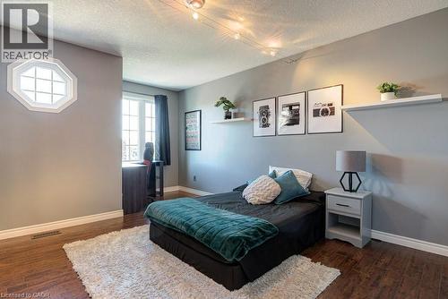 Hardwood-finish flooring featuring a decorative octagonal window and a multi-pane window - 61 Ditner Avenue, Baden, ON - Indoor Photo Showing Bedroom