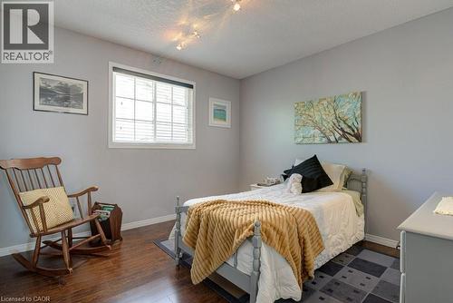 Bedroom featuring wood-finish flooring, light gray walls, and a window with white blinds - 61 Ditner Avenue, Baden, ON - Indoor Photo Showing Bedroom