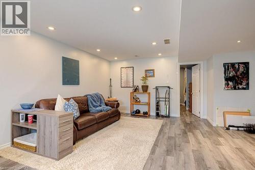 Spacious living area featuring light gray walls, recessed ceiling lighting, wood-finish flooring, and a large area rug - 61 Ditner Avenue, Baden, ON - Indoor