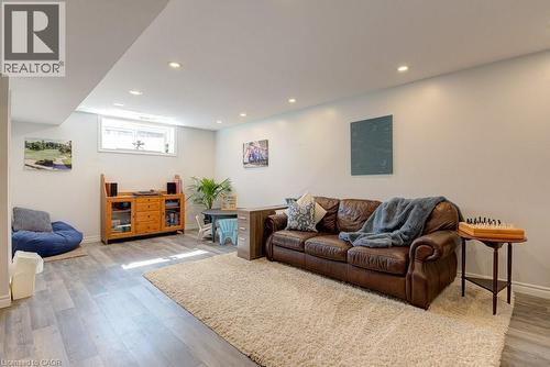 Spacious lower level featuring wood-finish flooring, recessed lighting, a white trim package, and a high window - 61 Ditner Avenue, Baden, ON - Indoor