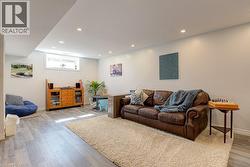 Spacious lower level featuring wood-finish flooring, recessed lighting, a white trim package, and a high window - 