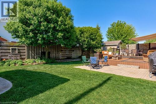 Expansive backyard featuring a multi-level wood deck, a paved patio, a storage shed, and mature trees - 61 Ditner Avenue, Baden, ON - Outdoor With Deck Patio Veranda