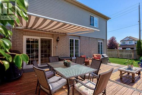 Expansive wood deck with a retractable striped awning - 61 Ditner Avenue, Baden, ON - Outdoor With Deck Patio Veranda With Exterior