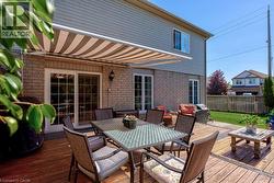 Expansive wood deck with a retractable striped awning - 