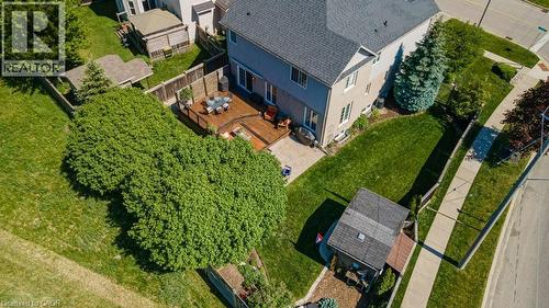 Rear exterior featuring a multi-level wood deck, expansive green lawn, and mature perimeter trees - 61 Ditner Avenue, Baden, ON - Outdoor With View