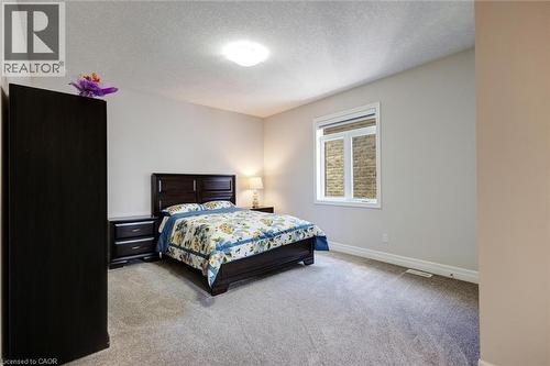 Spacious room with light neutral wall tones, textured ceiling, and gray carpeting - 57 Hollybrook Trail, Kitchener, ON 