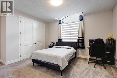 Room featuring light gray walls, textured carpet flooring, and a flush-mount ceiling light - 57 Hollybrook Trail, Kitchener, ON 