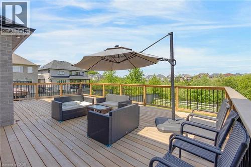 Spacious wooden deck featuring a natural wood railing with black balusters - 57 Hollybrook Trail, Kitchener, ON 