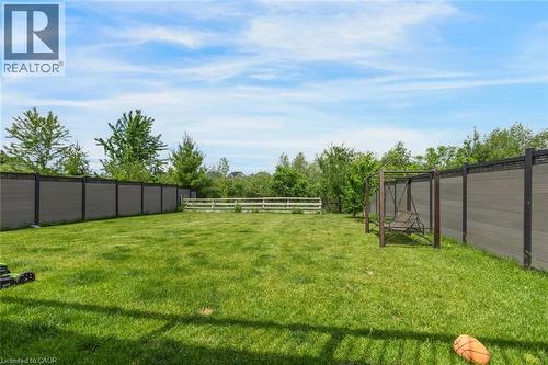 Expansive green lawn framed by a composite panel fence and a white split-rail fence - 57 Hollybrook Trail, Kitchener, ON 