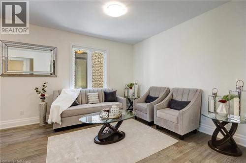 Bright living space featuring wood-finish flooring and a neutral color palette - 57 Hollybrook Trail, Kitchener, ON 