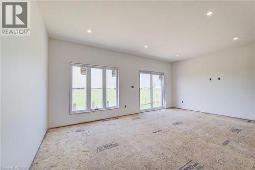 Spacious room featuring white walls, recessed ceiling lighting, a large triple window, and a sliding glass door - 114 Bedell Drive, Mapleton, ON - Indoor Photo Showing Other Room