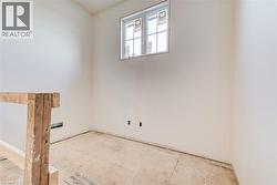 Unfinished room featuring white painted walls and a single window with white framing - 