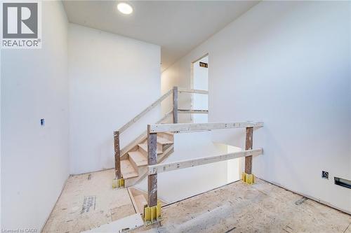 Unfinished interior staircase featuring exposed wood treads and temporary railing - 114 Bedell Drive, Mapleton, ON - Indoor Photo Showing Other Room