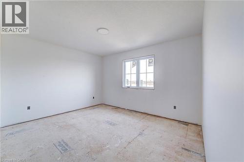 Light-filled room featuring white walls, a single window with white framing, and an overhead flush-mount light fixture - 114 Bedell Drive, Mapleton, ON - Indoor Photo Showing Other Room