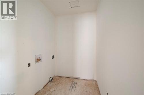 Dedicated utility space with white walls, rough plywood subfloor, and exposed plumbing connections - 114 Bedell Drive, Mapleton, ON - Indoor Photo Showing Other Room