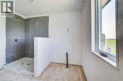 Unfinished bathroom space featuring a white shower pan, partially installed shower walls, an existing window, and a recessed ceiling light - 114 Bedell Drive, Mapleton, ON - Indoor
