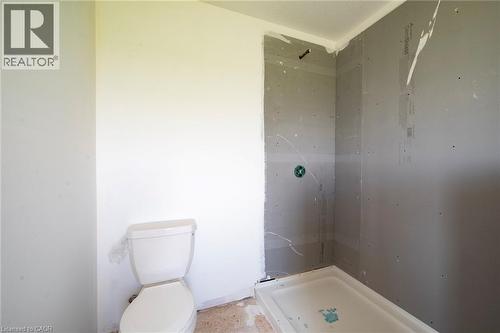 Bathroom featuring a white toilet and a shower stall with a pre-formed base - 114 Bedell Drive, Mapleton, ON - Indoor Photo Showing Bathroom