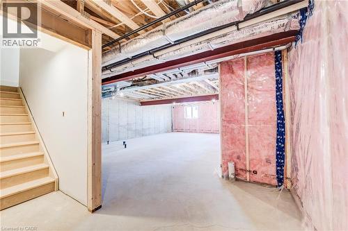 Unfinished basement offering expansive concrete flooring, exposed ceiling joists, structural steel beams, and partial insulation - 114 Bedell Drive, Mapleton, ON - Indoor Photo Showing Other Room