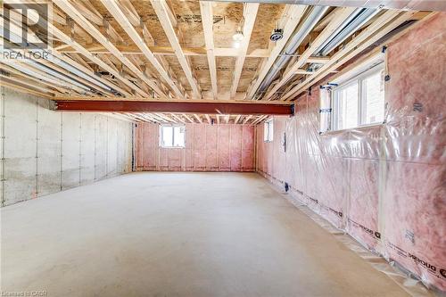 Unfinished basement featuring a concrete floor, exposed ceiling joists, two windows, and insulated framed walls - 114 Bedell Drive, Mapleton, ON - Indoor Photo Showing Basement