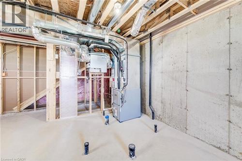Unfinished basement space featuring exposed concrete walls, wood framing, visible ductwork, and mechanical systems - 114 Bedell Drive, Mapleton, ON - Indoor Photo Showing Basement