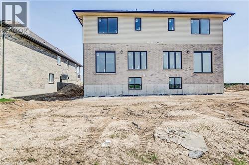 Rear exterior showcasing brick and siding facade with multiple black-framed windows - 114 Bedell Drive, Mapleton, ON - Outdoor With Exterior