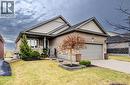 Single story home with a front lawn, driveway, a garage, a porch, and brick siding - 130 Bridge Crescent, Minto, ON 