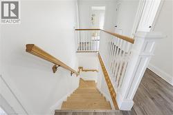 Hardwood stairs with coordinating handrails, white balusters, and a substantial newel post - 