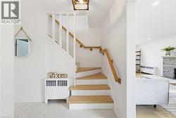 Staircase featuring wood-finish treads and handrails with white risers and balusters - 