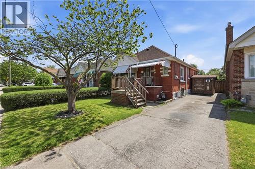 Red brick facade with a covered front porch - 97 Tragina Avenue S, Hamilton, ON 
