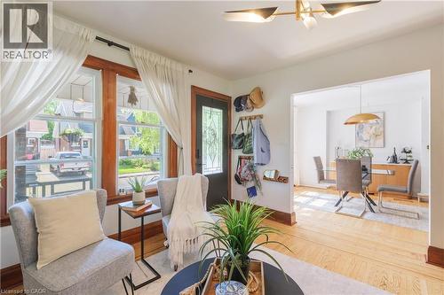 Living room featuring abundant natural light, hardwood flooring, and a decorative ceiling fixture - 41 Park Row N, Hamilton, ON 