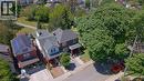 Traditional brick residence featuring a covered front porch, gabled roofline, and established front yard landscaping - 41 Park Row N, Hamilton, ON 
