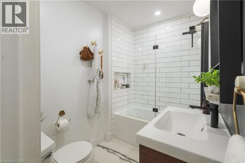 Bathroom featuring a tub/shower combination with subway tile surround and a glass partition - 41 Park Row N, Hamilton, ON 