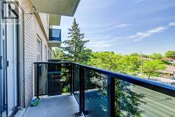 Exterior balcony featuring a concrete floor and black-framed glass railings - 