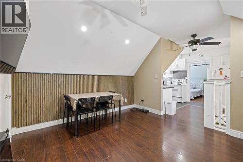 Open-concept living space featuring wood-finish flooring, a pitched ceiling, and a vertical slat accent wall - 54 E Chestnut Street E, St. Catharines, ON - Indoor Photo Showing Other Room