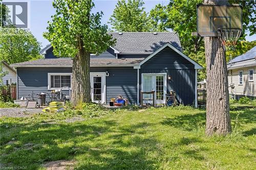 Rear exterior featuring dark blue horizontal siding and a gray shingled roof - 54 E Chestnut Street E, St. Catharines, ON - Outdoor