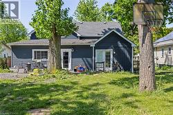 Rear exterior featuring dark blue horizontal siding and a gray shingled roof - 