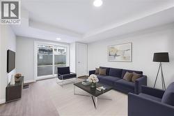 Living room featuring wood finished floors, recessed lighting, and a raised ceiling - 