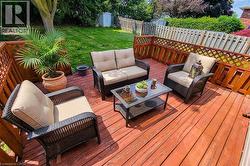 Spacious wood deck featuring a lattice privacy screen and a manicured lawn area - 