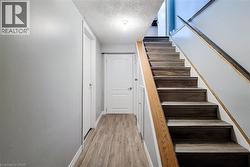 Staircase featuring wood-finish treads and risers, complemented by a natural wood handrail - 