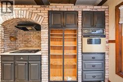 Brick archway with built-in cooktop and range hood - 