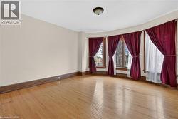 Wood-finish flooring throughout, complemented by a curved bay window feature - 