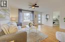 Bright living area featuring wood-finish flooring, a ceiling fan with integrated lighting, and a large window - 73 East 33Rd Street, Hamilton, ON 