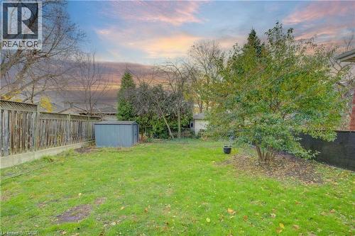 Expansive green lawn with mature perimeter trees and a wooden privacy fence - 73 East 33Rd Street, Hamilton, ON 