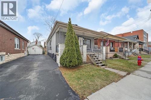 Single-story residence featuring a covered front porch with metal railings and steps - 106 Lottridge Street, Hamilton, ON 
