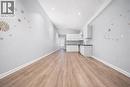 Expansive open-concept living area featuring wood-finish flooring, recessed lighting, and a modern kitchen with white cabinetry and dark countertops - 106 Lottridge Street, Hamilton, ON 