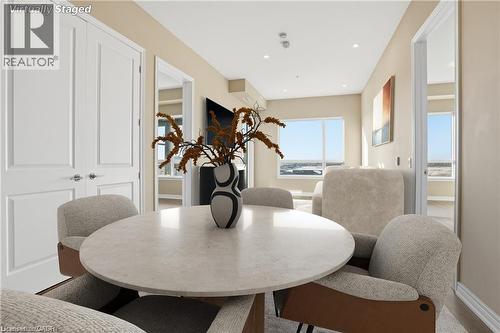 Dining area featuring a round light-toned table, recessed lighting, double panel doors, and neutral wall tones - 40 Esplanade Lane Unit# 614, Grimsby, ON 