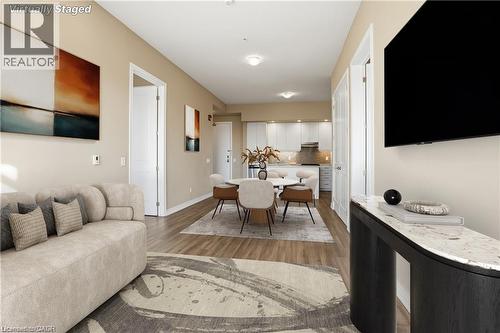 Open-concept living space featuring wood-finish flooring, recessed lighting, and a neutral color palette - 40 Esplanade Lane Unit# 614, Grimsby, ON 