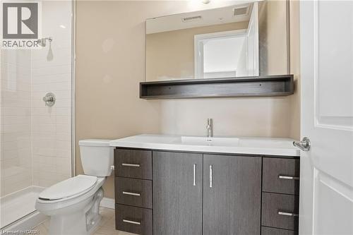 Contemporary bathroom featuring a dark wood-finish vanity with ample storage, an integrated rectangular sink, and a chrome faucet - 40 Esplanade Lane Unit# 614, Grimsby, ON 