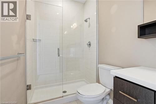 Bathroom featuring a glass-enclosed shower with white subway tile, a dark wood-finish vanity with a light-toned countertop, and chrome fixtures - 40 Esplanade Lane Unit# 614, Grimsby, ON 